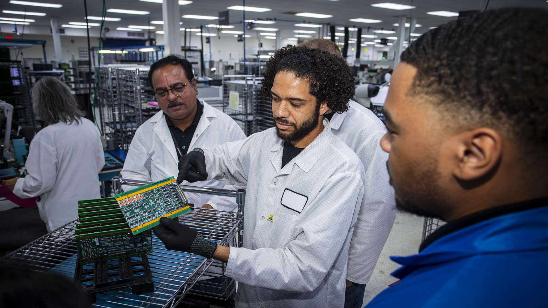 Box Build process at Variosystems: A technician carefully inserts a circuit board into a dedicated assembly station.